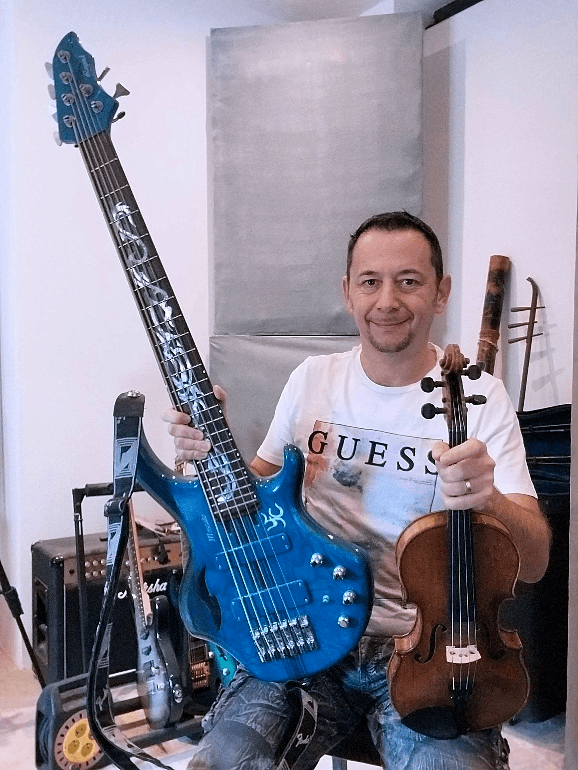 a man holding a blue bass and a violin